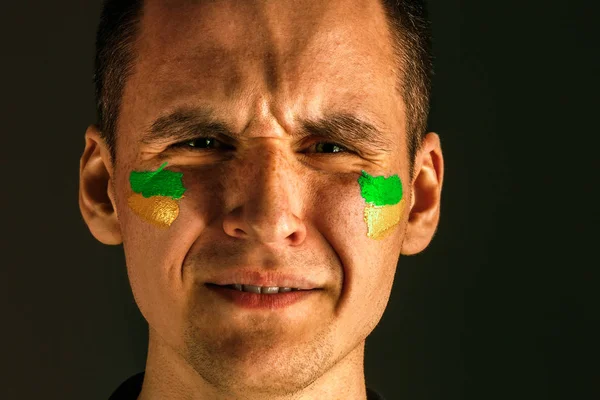 Porträt eines Mannes mit der brasilianischen Flagge im Gesicht. — Stockfoto