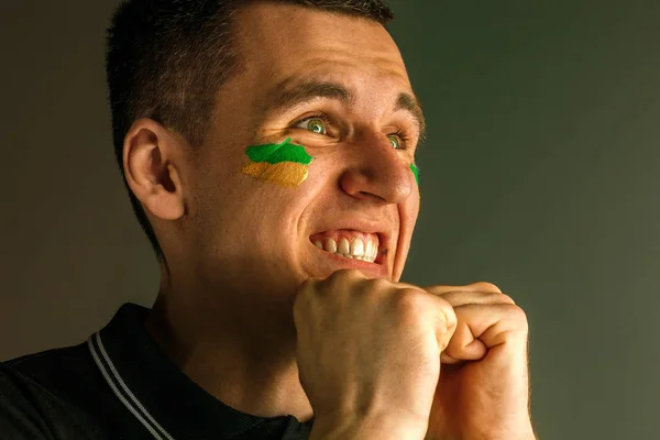 ブラジルの旗を持つ男の肖像は、彼に顔を描いた. — ストック写真
