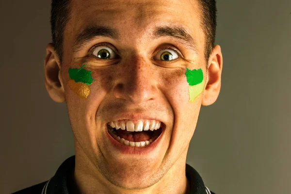 Porträt eines Mannes mit der brasilianischen Flagge im Gesicht. — Stockfoto