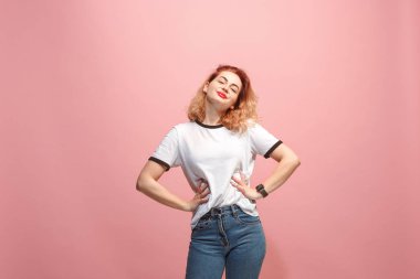 Ayakta ve pembe bir arka plan karşı gülümseyerek mutlu bir iş kadını.