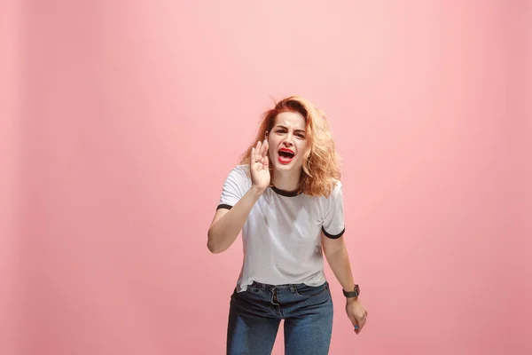 The young emotional angry woman screaming on pink studio background — Stock Photo, Image