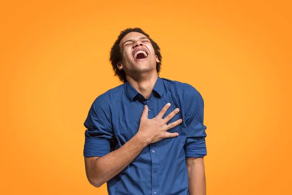 De gelukkige zakenman permanent en glimlachend tegen oranje achtergrond. — Stockfoto