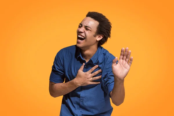 Den glada affärsman står och ler mot orange bakgrund. — Stockfoto