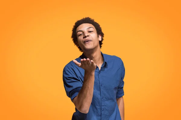 Retrato de hombre afro atractivo con beso aislado sobre fondo naranja — Foto de Stock