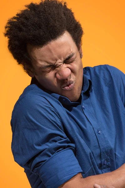 Déjeme pensar. Dudoso hombre pensativo con expresión reflexiva haciendo elección contra fondo naranja — Foto de Stock