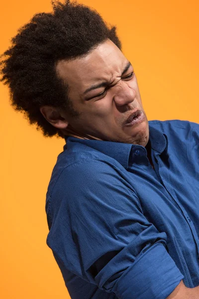 Let me think. Doubtful pensive man with thoughtful expression making choice against orange background — Stock Photo, Image