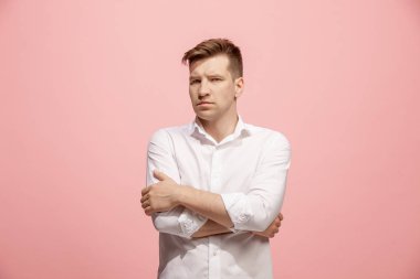Ayakta ve kamera pembe bir arka plan karşı bakarak ciddi iş adamı.