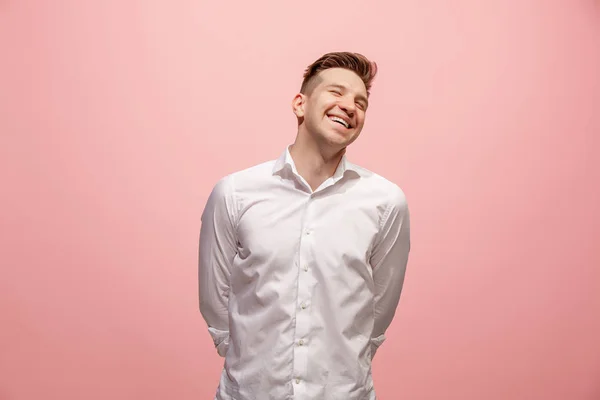 Der glückliche Geschäftsmann steht vor rosa Hintergrund und lächelt. — Stockfoto