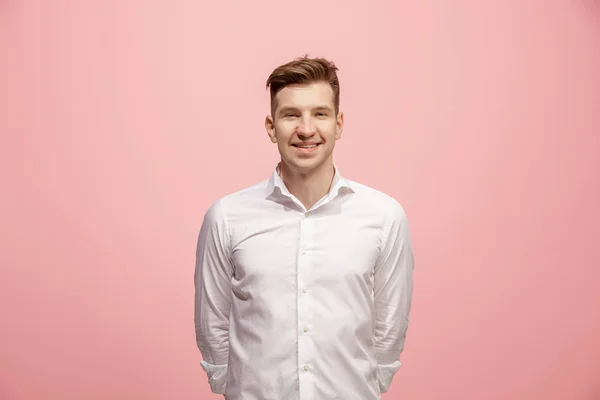 El hombre de negocios feliz de pie y sonriendo sobre el fondo rosa . — Foto de Stock