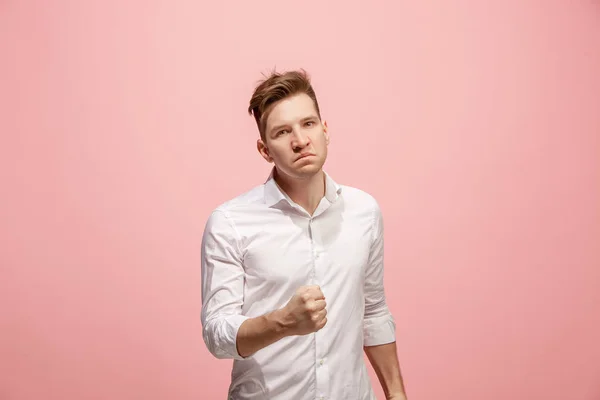 Der junge emotionale wütende Mann schreit auf rosa Studiohintergrund — Stockfoto