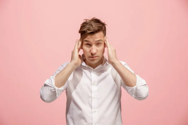 Un hombre con dolor de cabeza. Aislado sobre fondo rosa . — Foto de Stock