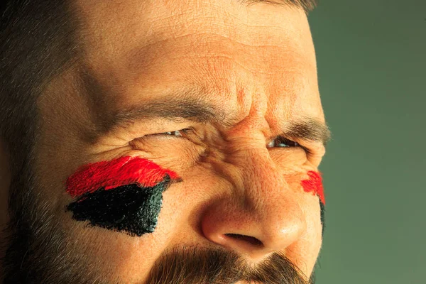 Retrato de um homem com a bandeira da Alemanha pintado sobre ele rosto . — Fotografia de Stock