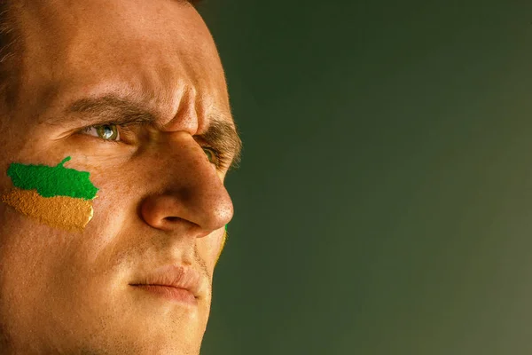 Retrato de un hombre con la bandera del Brasil pintado en su cara . — Foto de Stock