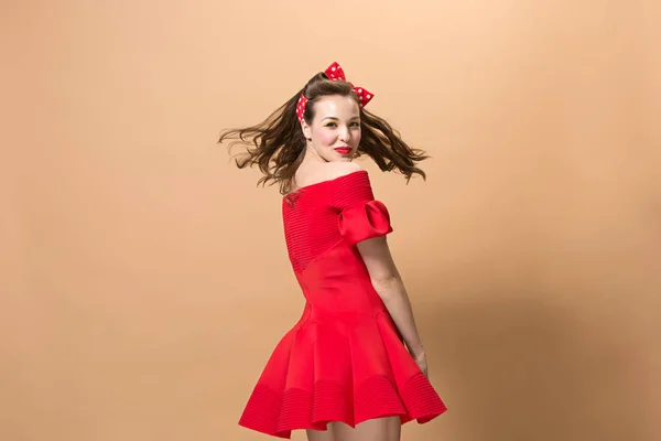 Hermosa mujer joven con pinup maquillaje y peinado. Estudio sobre fondo pastel — Foto de Stock