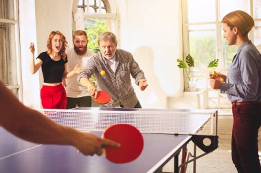 Ping pong Masa Tenisi oynarken mutlu genç arkadaş grubu