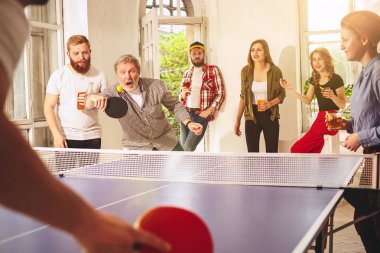 Ping pong Masa Tenisi oynarken mutlu genç arkadaş grubu