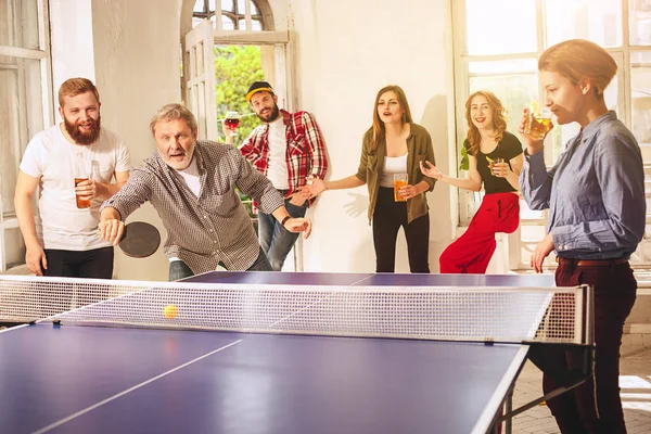 Grupo de jóvenes amigos felices jugando ping pong tenis de mesa —  Fotos de Stock