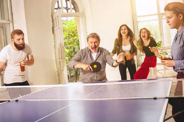 Grupo de jóvenes amigos felices jugando ping pong tenis de mesa — Foto de Stock