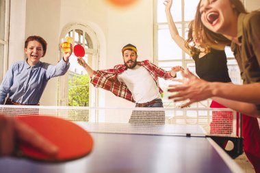 Ping pong Masa Tenisi oynarken mutlu genç arkadaş grubu
