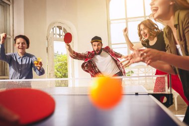Ping pong Masa Tenisi oynarken mutlu genç arkadaş grubu