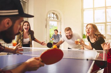 Ping pong Masa Tenisi oynarken mutlu genç arkadaş grubu