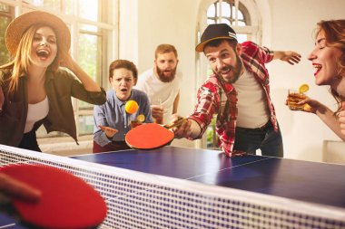 Ping pong Masa Tenisi oynarken mutlu genç arkadaş grubu