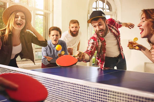 Grupo de jóvenes amigos felices jugando ping pong tenis de mesa —  Fotos de Stock