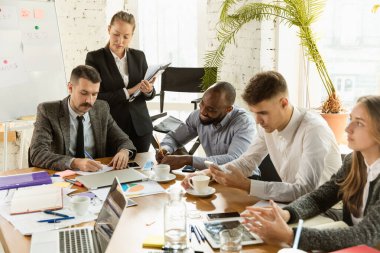 Bir grup genç iş adamı toplantı yapıyor, yaratıcı bir ofis.