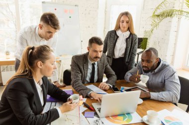 Bir grup genç iş adamı toplantı yapıyor, yaratıcı bir ofis.