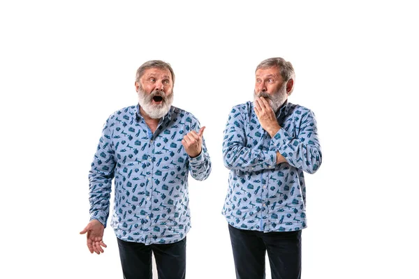 Hombre mayor discutiendo consigo mismo en el fondo del estudio blanco . — Foto de Stock