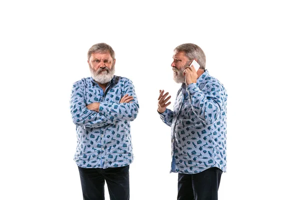 Senior man ruzie met zichzelf op witte studio achtergrond. — Stockfoto