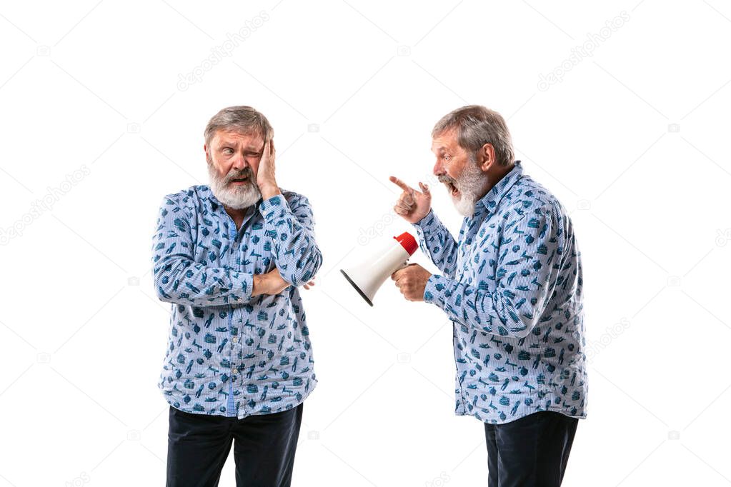 Senior man arguing with himself on white studio background.