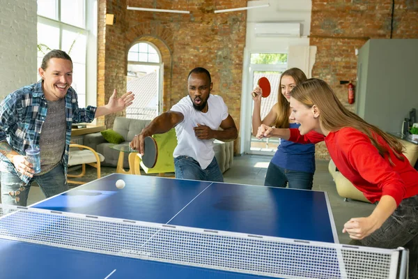 Jóvenes jugando al tenis de mesa en el lugar de trabajo, divirtiéndose — Foto de Stock