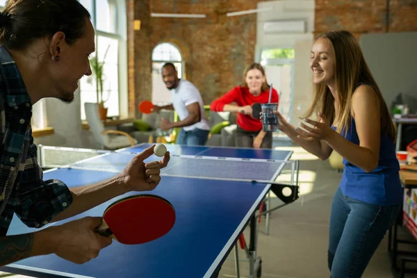 Jóvenes jugando al tenis de mesa en el lugar de trabajo, divirtiéndose — Foto de Stock