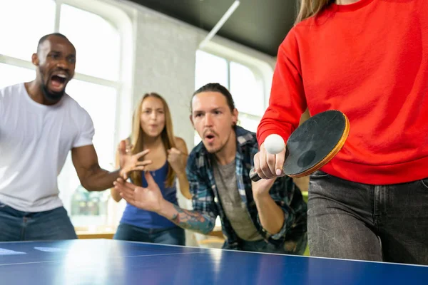 Jóvenes jugando al tenis de mesa en el lugar de trabajo, divirtiéndose —  Fotos de Stock