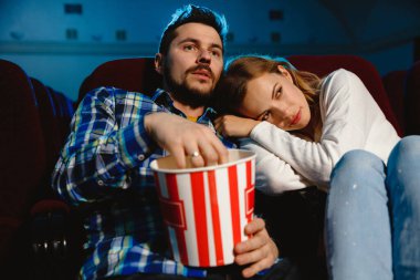 Çekici, genç, beyaz bir çift sinemada film izliyor.