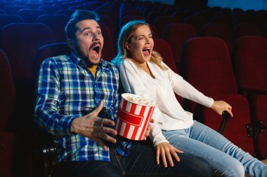 Çekici, genç, beyaz bir çift sinemada film izliyor.