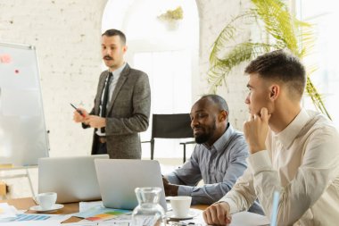 Bir grup genç iş adamı toplantı yapıyor, yaratıcı bir ofis.