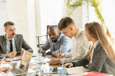 Bir grup genç iş adamı toplantı yapıyor, yaratıcı bir ofis.
