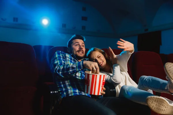 Atraente jovem casal caucasiano assistindo a um filme em um cinema — Fotografia de Stock