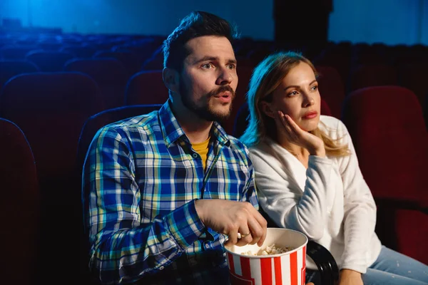 Attrayant jeune couple caucasien regarder un film à un cinéma — Photo