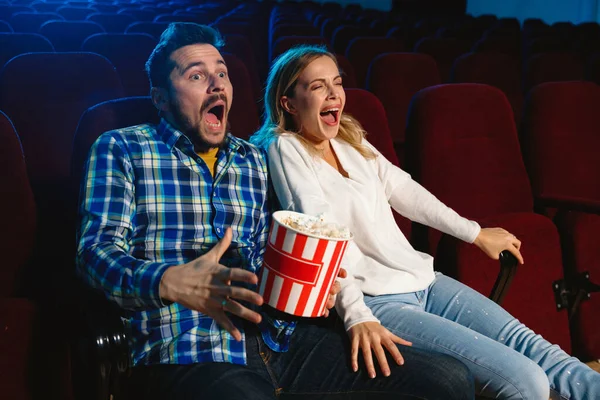 Attractive young caucasian couple watching a film at a movie theater — Stock Photo, Image