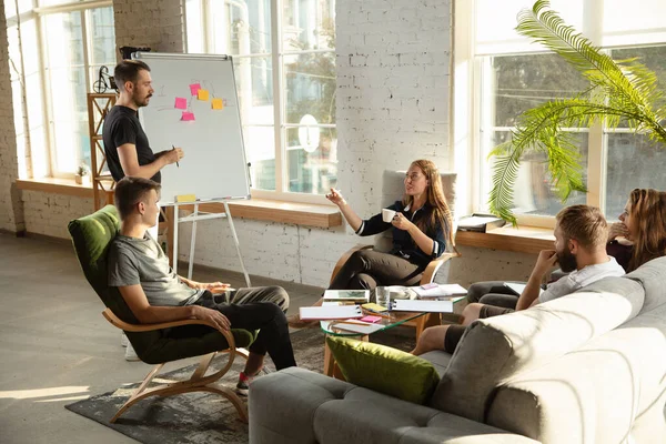 Grupo de jóvenes trabajadores de oficina caucásicos tienen reunión creativa para discutir nuevas ideas — Foto de Stock