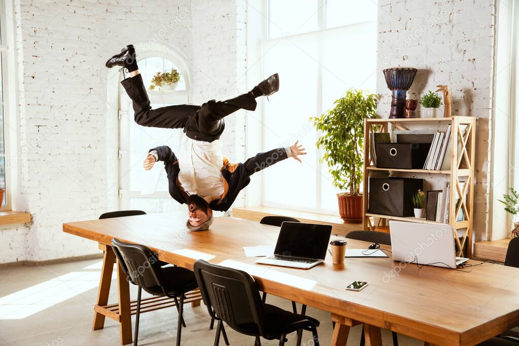 Businessman having fun dancing break dance in the office at work