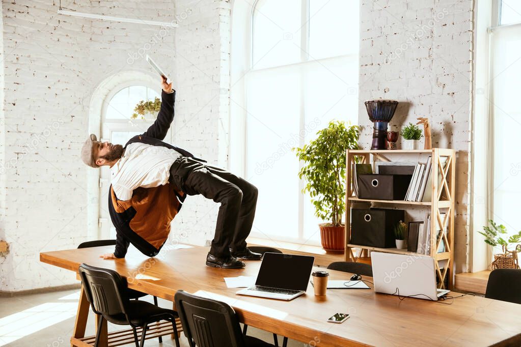 Businessman having fun dancing break dance in the office at work