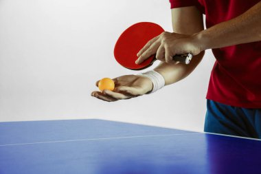 Young man playing table tennis on white studio background clipart
