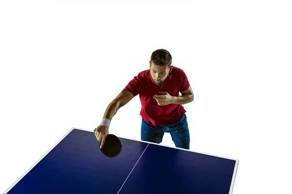 Jovem jogando tênis de mesa no fundo do estúdio branco — Fotografia de Stock