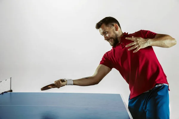 Joven jugando al tenis de mesa sobre fondo blanco del estudio —  Fotos de Stock