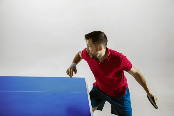 Joven jugando al tenis de mesa sobre fondo blanco del estudio —  Fotos de Stock