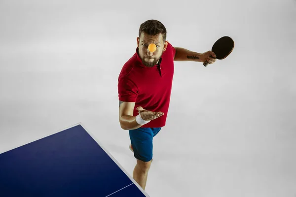 Joven jugando al tenis de mesa sobre fondo blanco del estudio —  Fotos de Stock